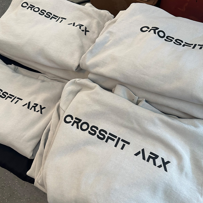 Folded light-colored apparel with black CrossFit ARX logos