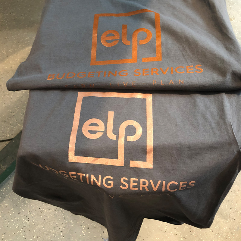 ELP Budgeting Services logos in copper-colored ink on dark shirts